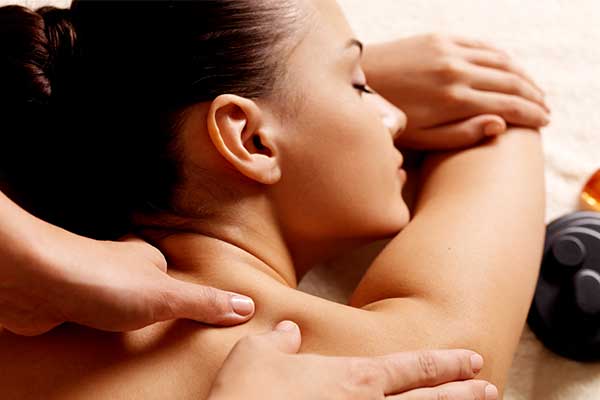 A therapist working on a client's neck and shoulders during a relaxing massage session